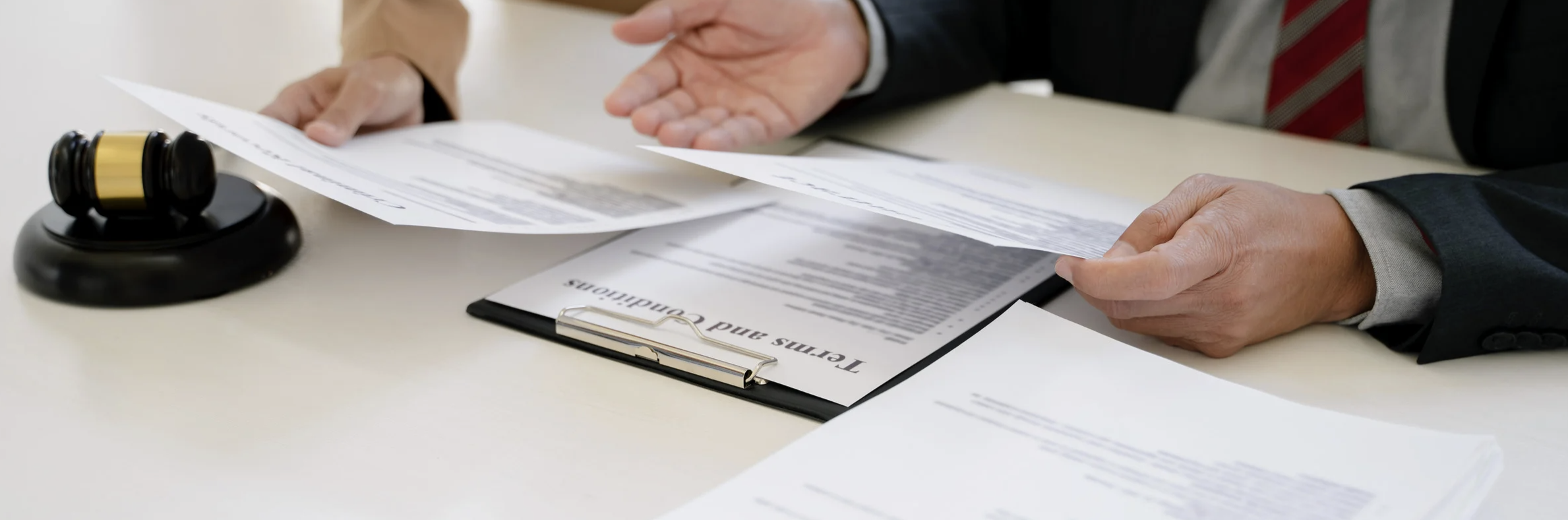 A business lawyer looks over paperwork at a desk.