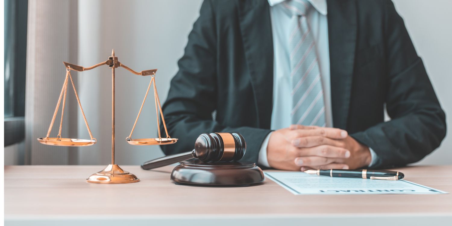 Business Attorney sitting at desk with scales of justice