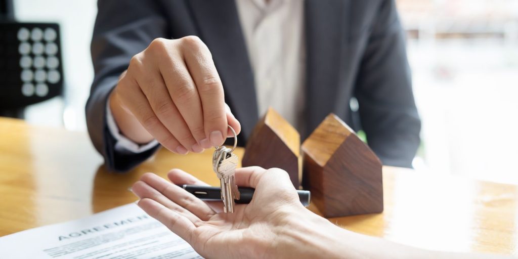 Commercial Real Estate Transaction: Keys are handed to a business owner after purchasing a property.