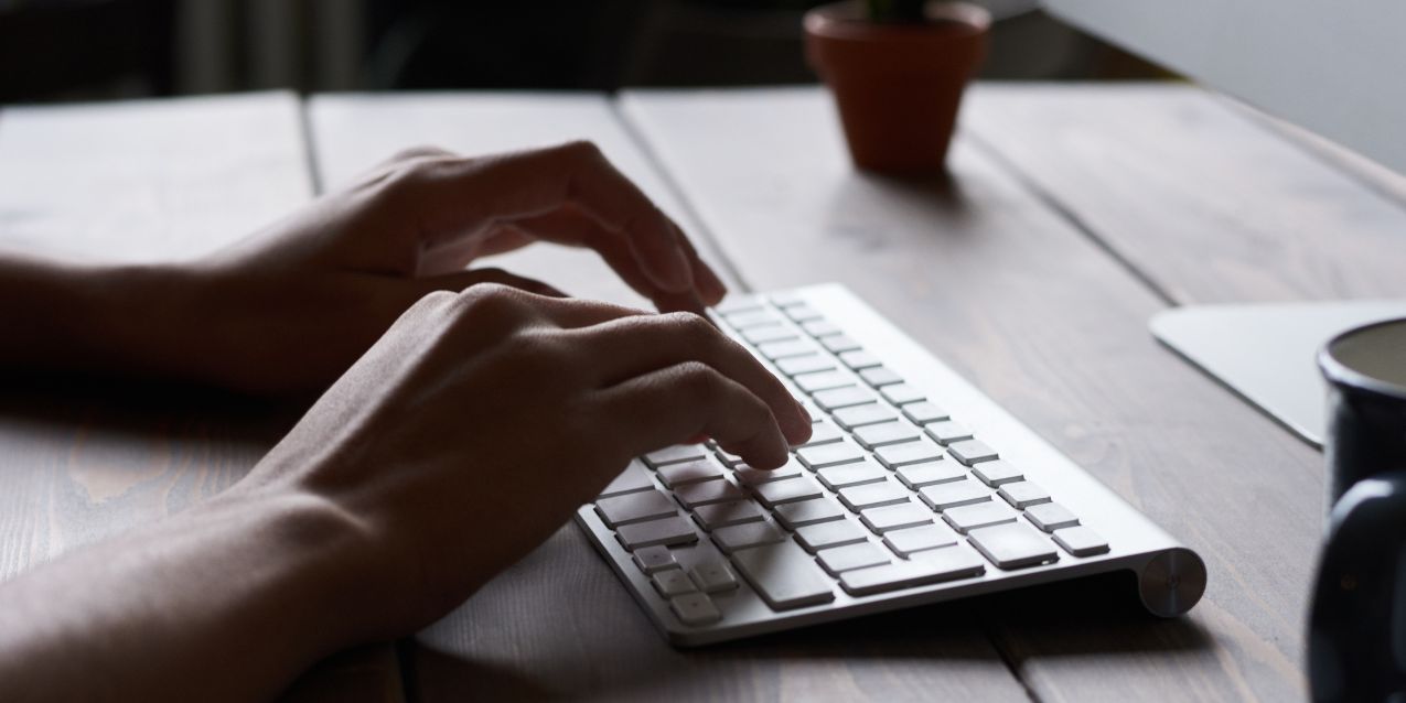 Hands type on a computer keyboard