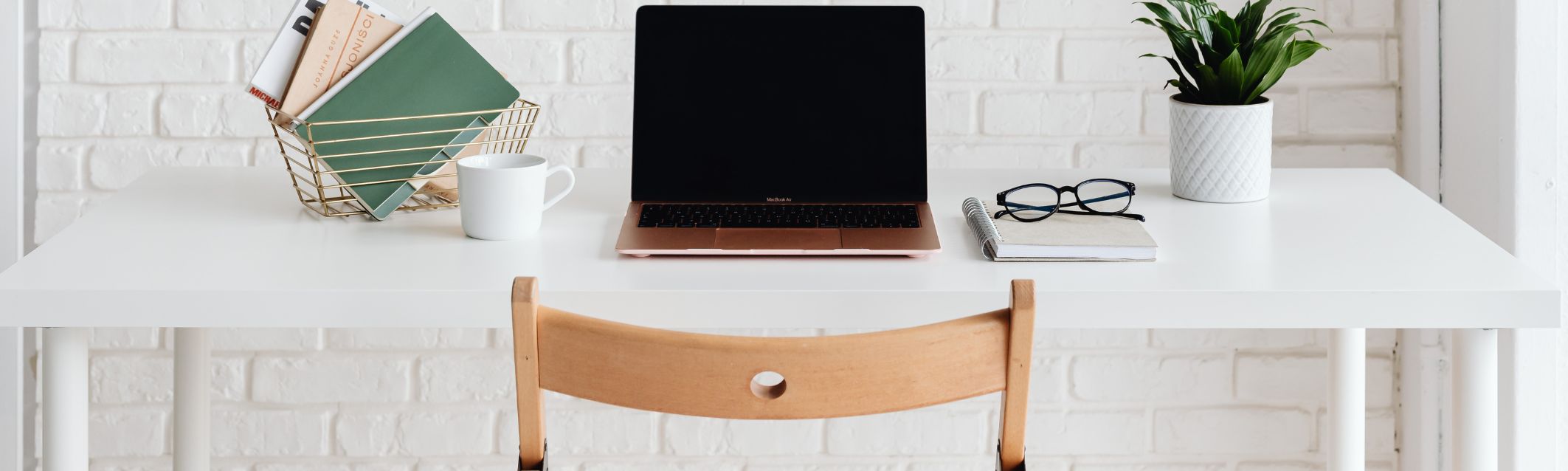A desk with notebooks and a plant.